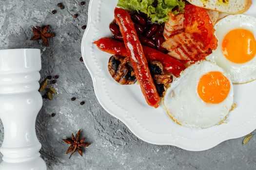 Fried breakfast with bacon, sausages and baked beans.