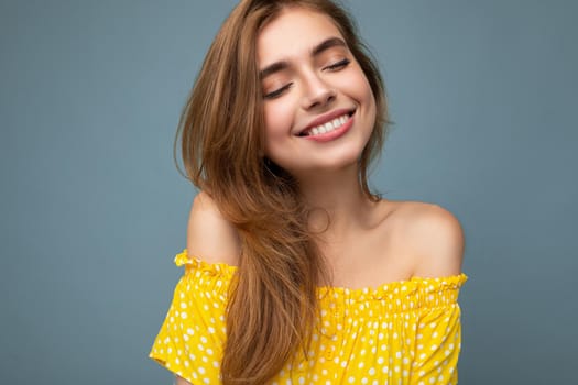 Closeup photo of young smiling cute beautiful dark blonde woman with sincere emotions isolated on background wall with copy space wearing stylish summer yellow dress. Positive concept.