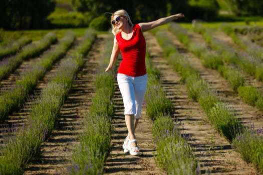 Woman standing with open arms on a lavender field