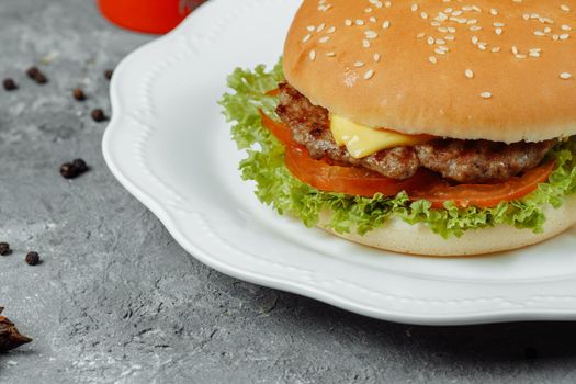 hamburger with fries and salad on the plate.