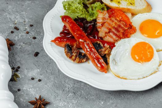 Fried breakfast with bacon, sausages and baked beans.