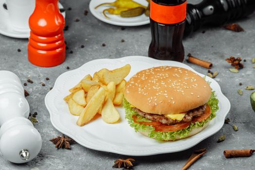 hamburger with fries and salad on the plate.