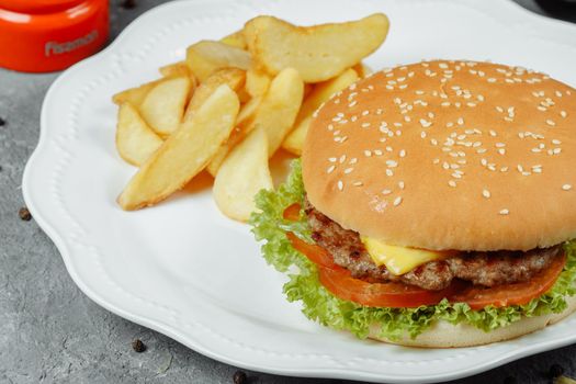 hamburger with fries and salad on the plate.