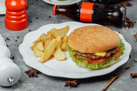 hamburger with fries and salad on the plate.