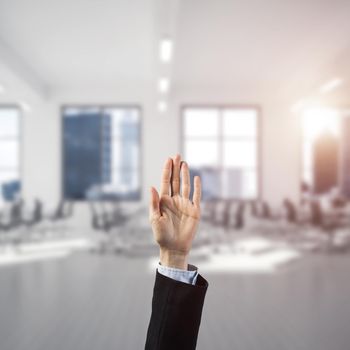 Close of businesswoman hand touching screen with palm and office at background