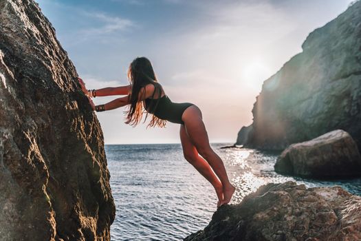 Young woman in swimsuit with long hair practicing stretching outdoors on yoga mat by the sea on a sunny day. Women's yoga fitness pilates routine. Healthy lifestyle, harmony and meditation concept.