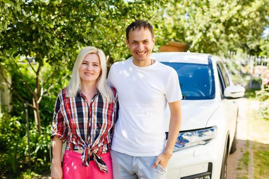 portrait of happy beautiful couple standing near the car