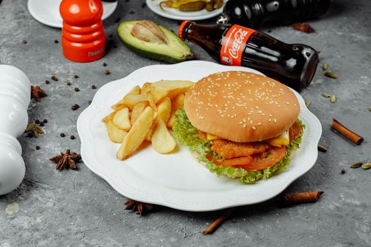 hamburger with fries and salad on the plate.