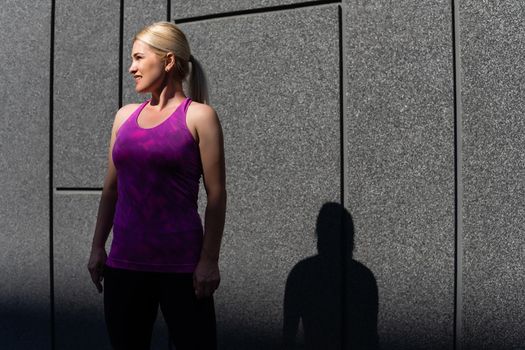 Fitness sport woman in fashion sportswear doing yoga fitness exercise in the street, outdoor sports, urban style