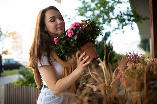 European woman chooses flowers as a gift in a street garden stall.