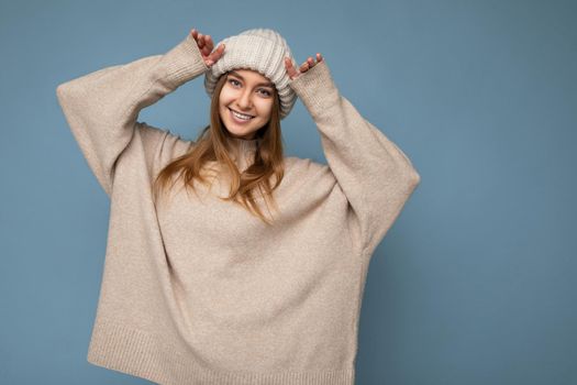 Beautiful positive happy young dark blonde woman isolated over colourful background wall wearing casual stylish clothes feeling sincere emotions looking at camera.