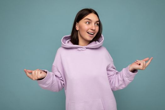 Shot of attractive happy smiling young woman wearing casual outfit standing isolated over colourful background with empty space looking to the side.