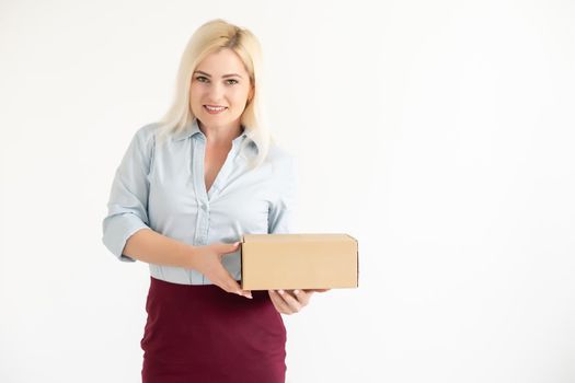 A young beautiful caucasian woman holding a box in her hands.