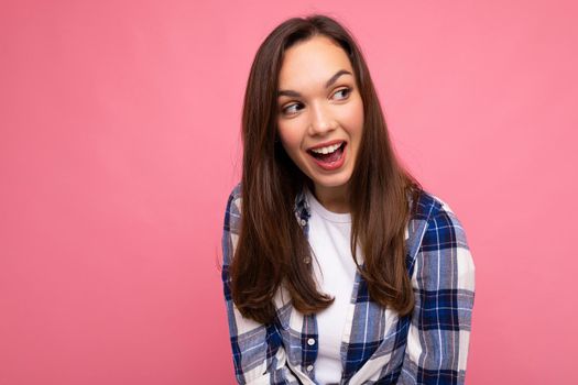 Young beautiful brunet woman. Trendy lady in casual summer hipster shirt . Positive female shows facial sincere emotions. Funny model isolated on pink background with free space.