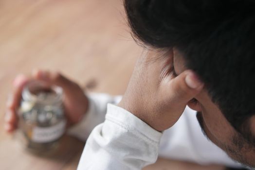 Depressed man feeling sick and worried about financial problem.