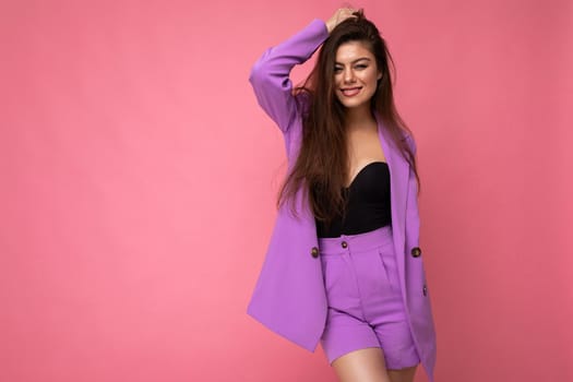 Young happy smiling brunette woman nice-looking attractive charming elegant fashionable wearing stylish suit with jacket isolated over pink background with copy space.