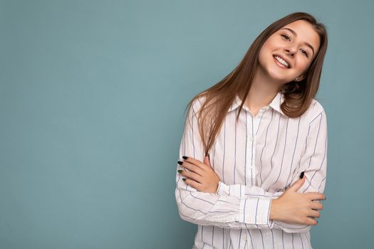 Photo of beautiful positive smiling adult woman wearing stylish clothes standing isolated on colorful background with copy space looking at camera.