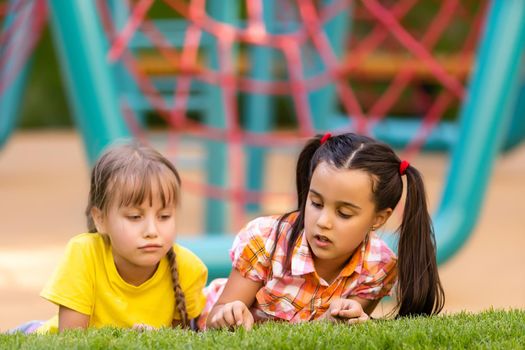 Portrait of two little girls sisters fighting on home backyard. Friends girls having fun. Lifestyle candid family moment of siblings quarreling playing together.