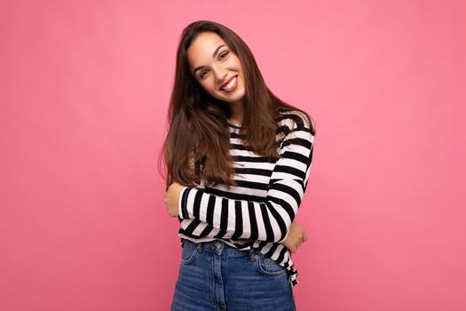 Portrait of positive cheerful fashionable woman in casual clothes isolated on pink background with copy space.