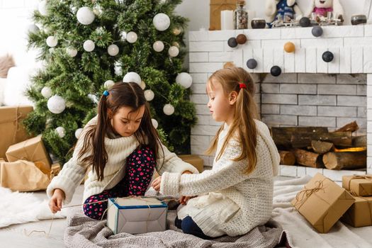 two little girls Sharing a Surprise on Christmas Morning.