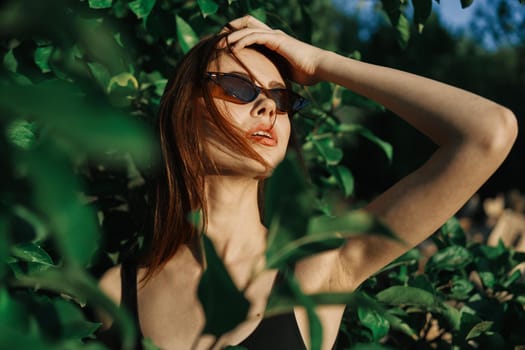 pretty woman wearing sunglasses green leaves posing summer. High quality photo