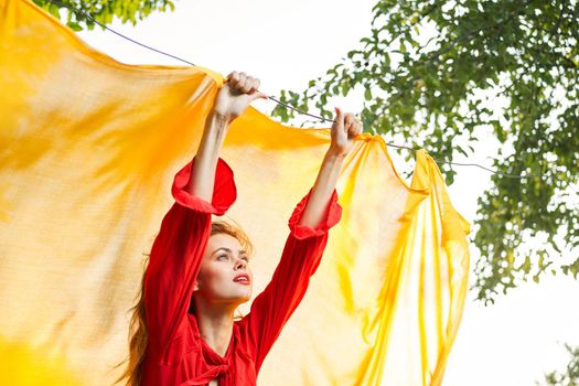 woman in red dress outdoors yellow bedspread. High quality photo