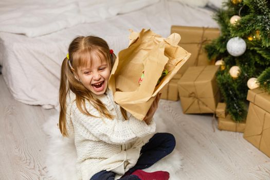 Happy little smiling girl with christmas gift box