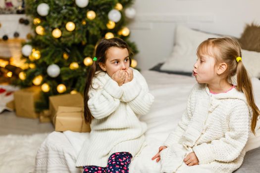 two little girls Sharing a Surprise on Christmas Morning.