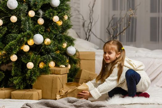 Happy little smiling girl with christmas gift box