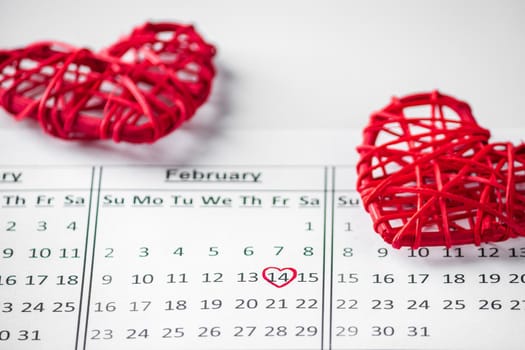 Calendar Reminder - Valentine's Day February 14th. Date closeup on a background of red hearts. Selective focus