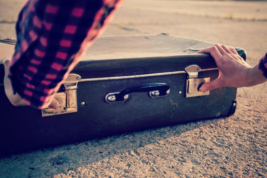 Traveler woman opens retro suitcase, close-up, face is not visible