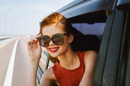 pretty woman in sunglasses rides in a travel car. High quality photo