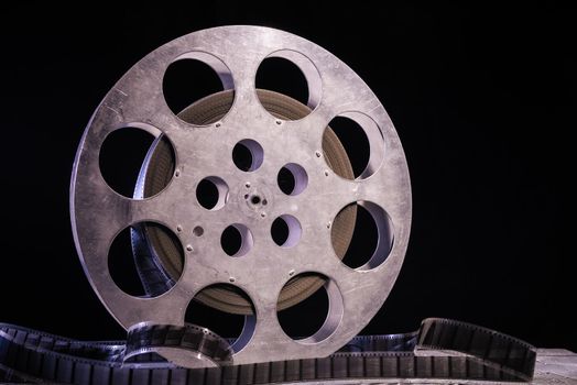 35 mm film reel with dramatic lighting on a dark background - image