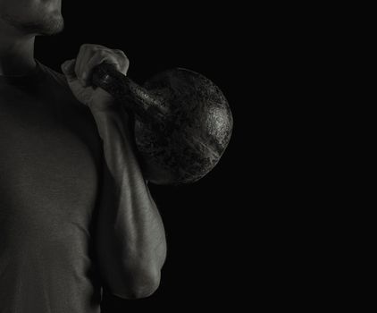 Man exercising with a kettlebell, black and white image