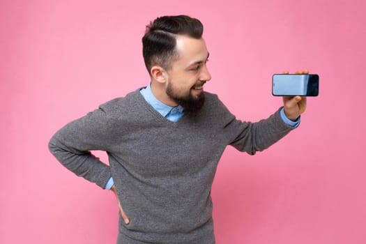 Closeup photo of amazing guy holding modern telephone hands casual outfit isolated on bright pink background.