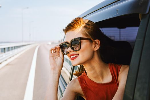 pretty woman in sunglasses rides in a travel car. High quality photo