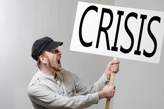 Angry protesting worker with protest sign inscription crisis.