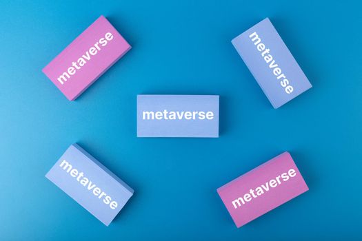 Metaverse modern minimal concept in blue colors. Written metaverse single word on blue and pink rectangles against blue background. Future technologies.