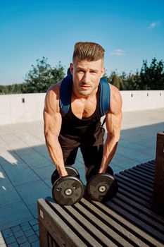 athletic man pumped up body in the park workout fitness fresh air. High quality photo