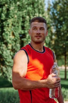 athletic man with dumbbells in his hands outdoors in the park. High quality photo