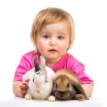 baby girl in a pink T-shirt with two small rabbits isolated on white background