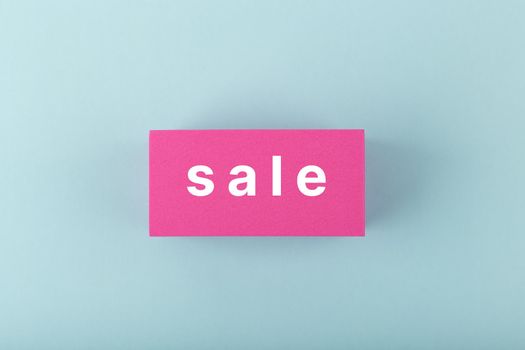 Sale elegant minimal concept. Sale written on pink tablets on bright pastel blue background.