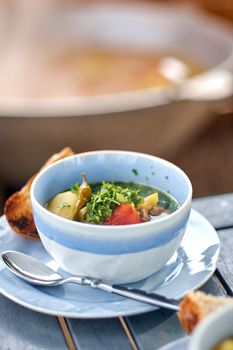 shurpa asian soup with meat and vegetables on wooden table. Copy space for your text.