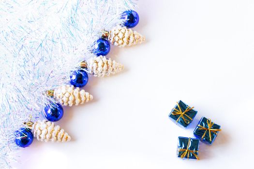 Christmas composition. Christmas decorations blue and gold on a white background with tinsel. Flat lay, top view, copy space.