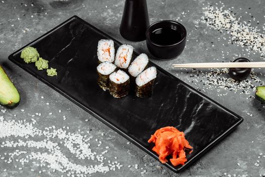 Simple maki with shrimp. Sushi on a gray background.