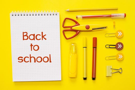 School supplies. Yellow and red colors. Flat lay composition. Text Back to school.