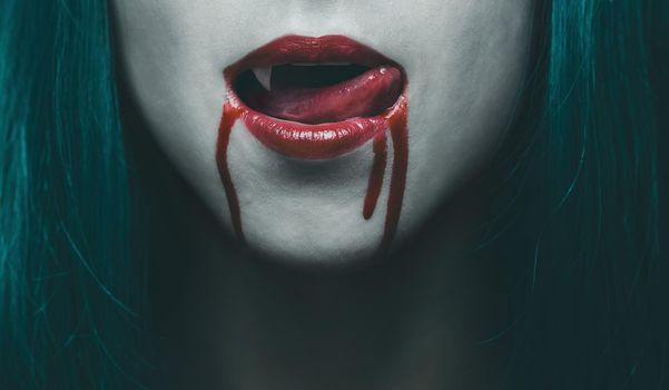 Sensual female vampire lips in blood, close-up image. Halloween or horror theme