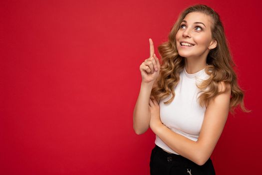 Photo of young positive happy smiling beautiful woman with sincere emotions wearing stylish clothes isolated over background with copy space and having an idea.