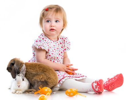 Easter photos. Cute little girl in a summer dress with two rabbits on white background