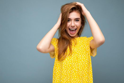 Young funny happy attractive dark blonde woman with sincere emotions isolated on background wall with copy space wearing stylish summer yellow dress. Positive concept.